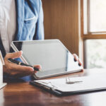 Real estate agent presenting documents on a tablet using an easy electronic signature app, demonstrating the convenience of Esignature for Real Estate deals.