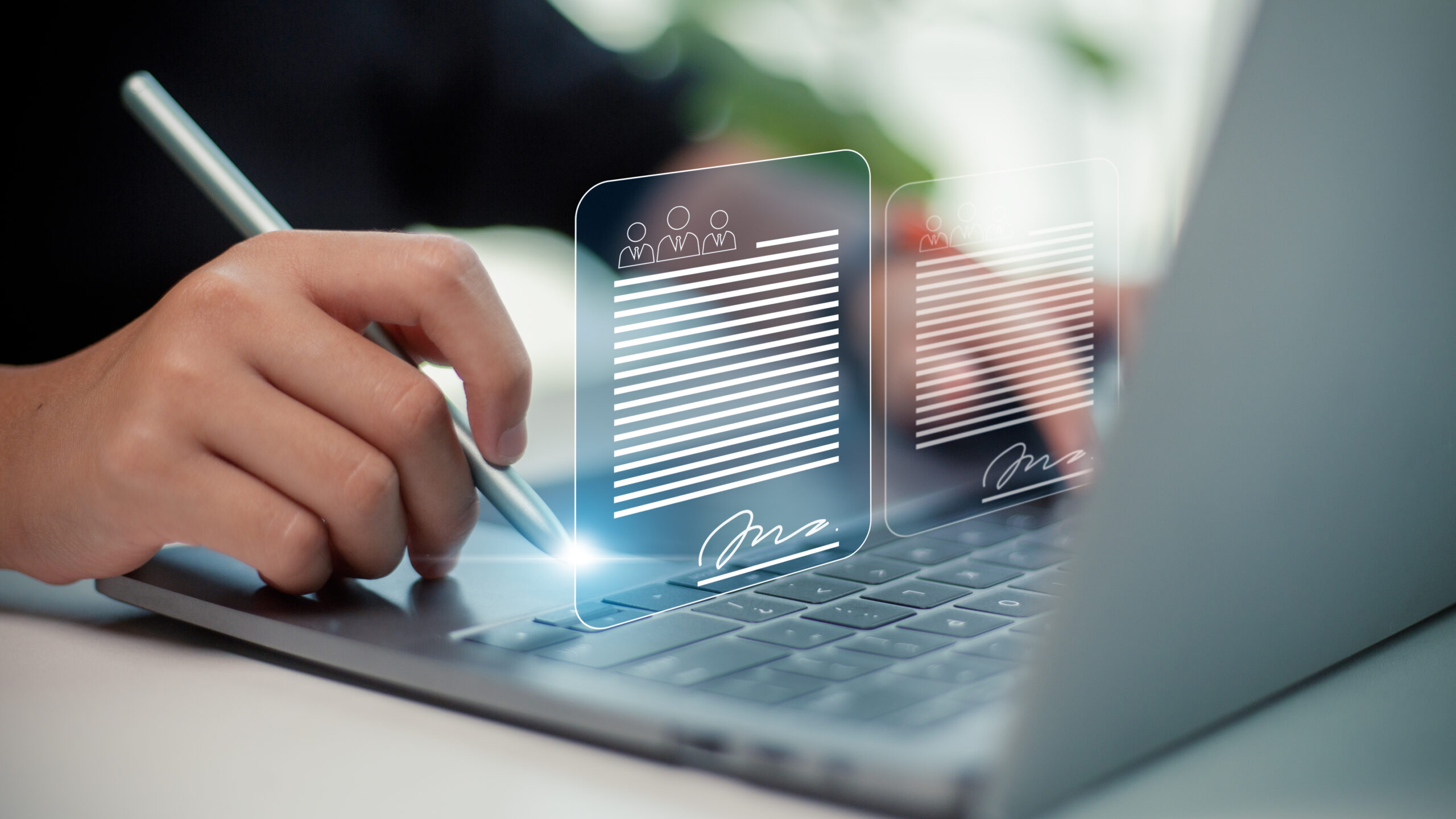 Person using laptop with holographic digital documents floating above keyboard, showing profile icons, text lines, and signatures, representing electronic document management and digital signature technology