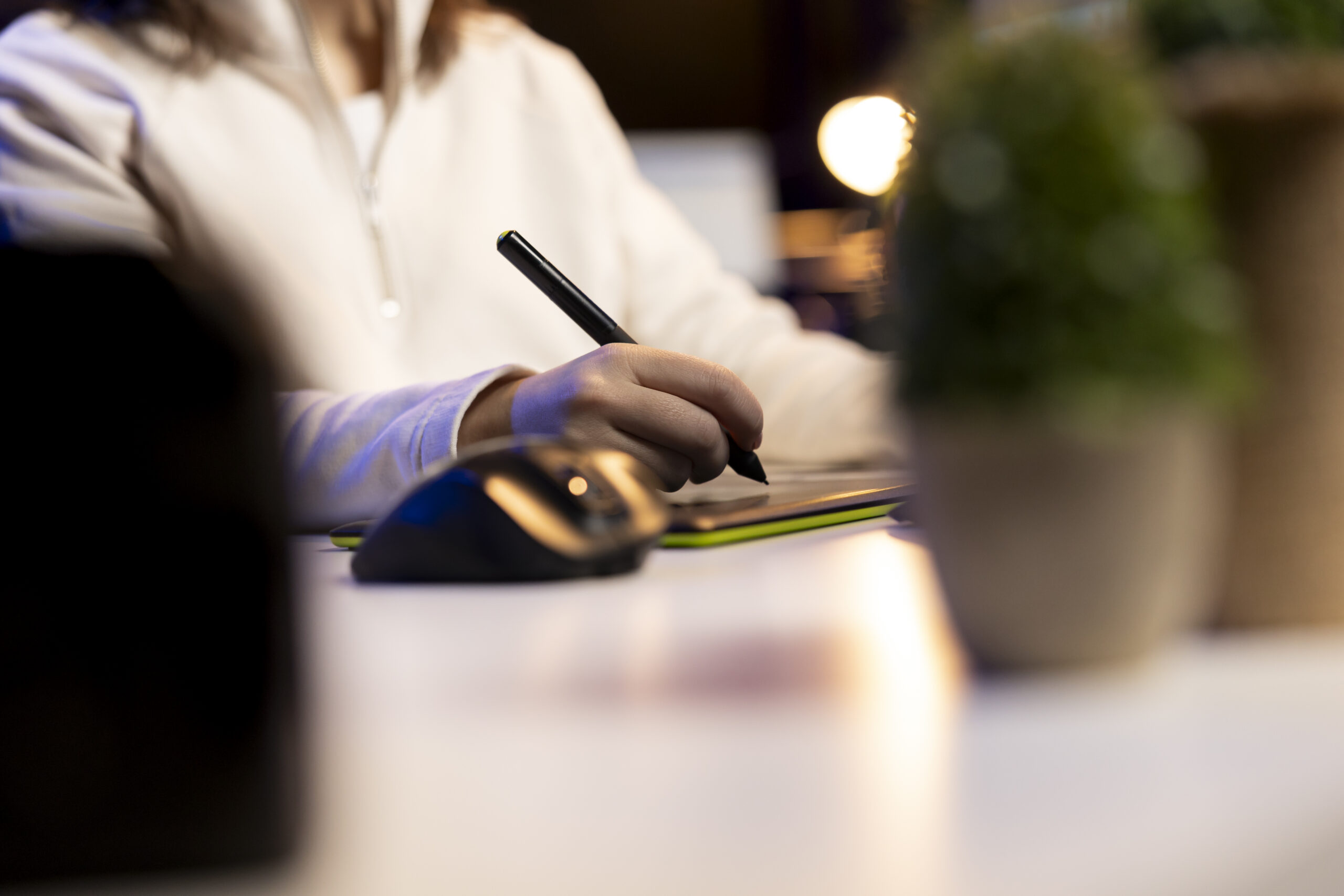 Individual using a digital pad and stylus to create e-signature online, demonstrating modern electronic signatures for secure digital workflows.