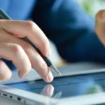 Professional using a digital tablet to apply Electronic Signatures through an Esignature app for sales contracts, ensuring fast and secure contract approvals.