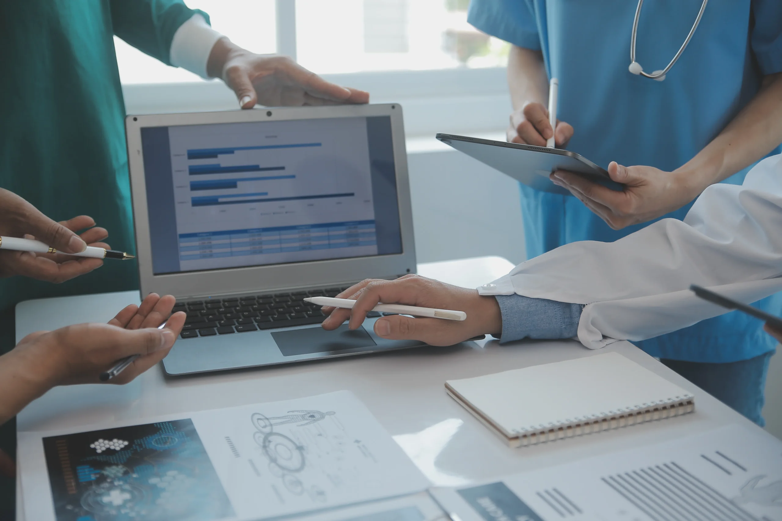 Medical team reviewing patient data on a laptop and tablet using Healthcare eSignatures and electronic signatures to streamline clinical workflows.