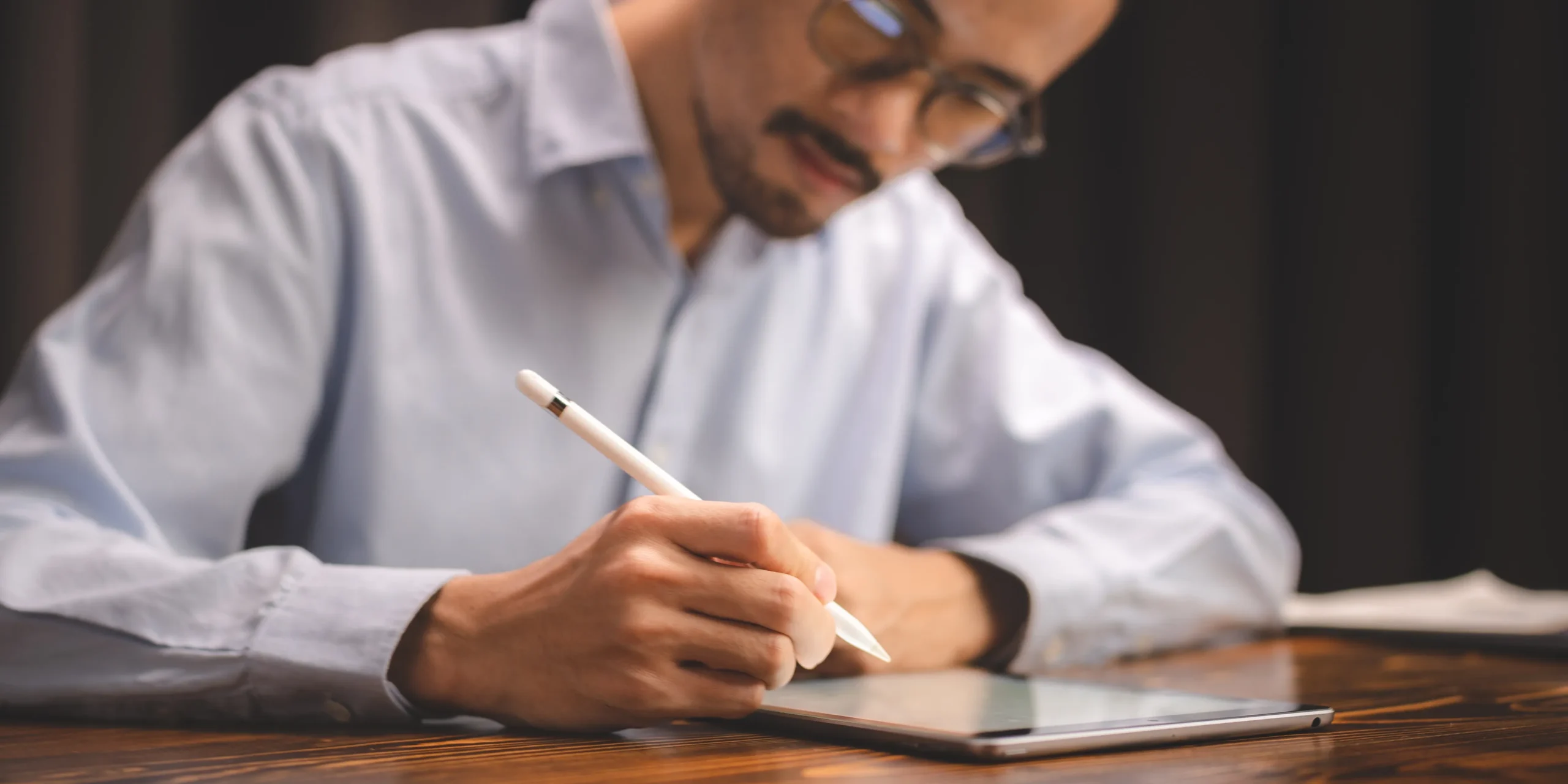Professional using a tablet and stylus to apply an e-signature, demonstrating a secure e-signature solution for digital document approval.