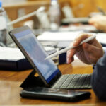 Professional using a tablet and stylus to sign documents digitally with electronic signature software and a modern e signature app.