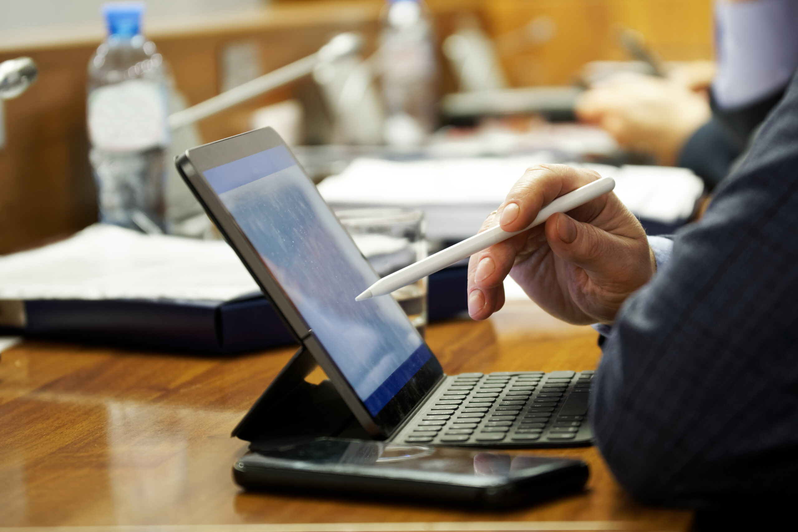 Professional using a tablet and stylus to sign documents digitally with electronic signature software and a modern e signature app.