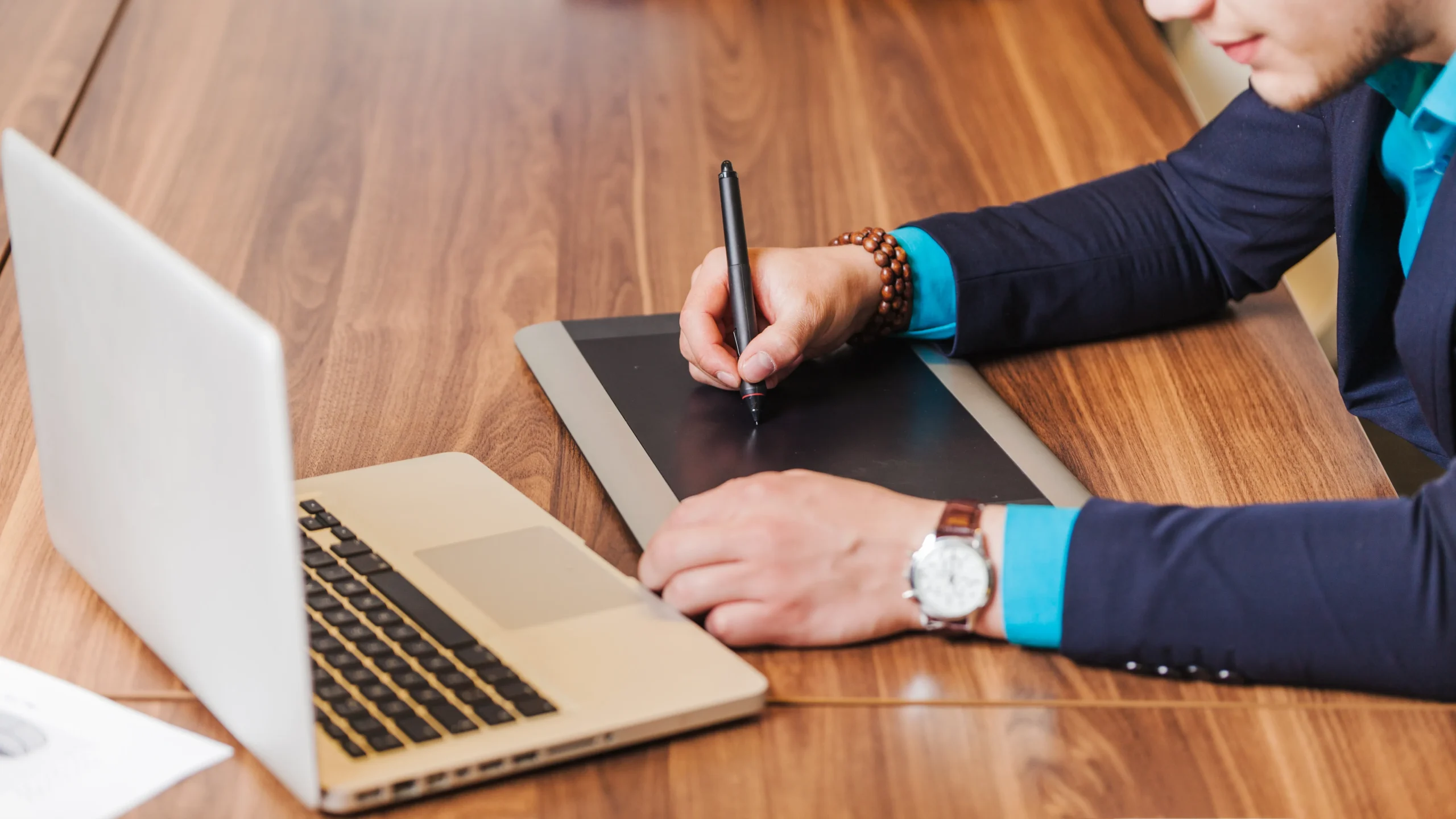 Business professional creating an e-signature on a digital pad connected to a laptop, highlighting an efficient e-signature solution for online agreements.