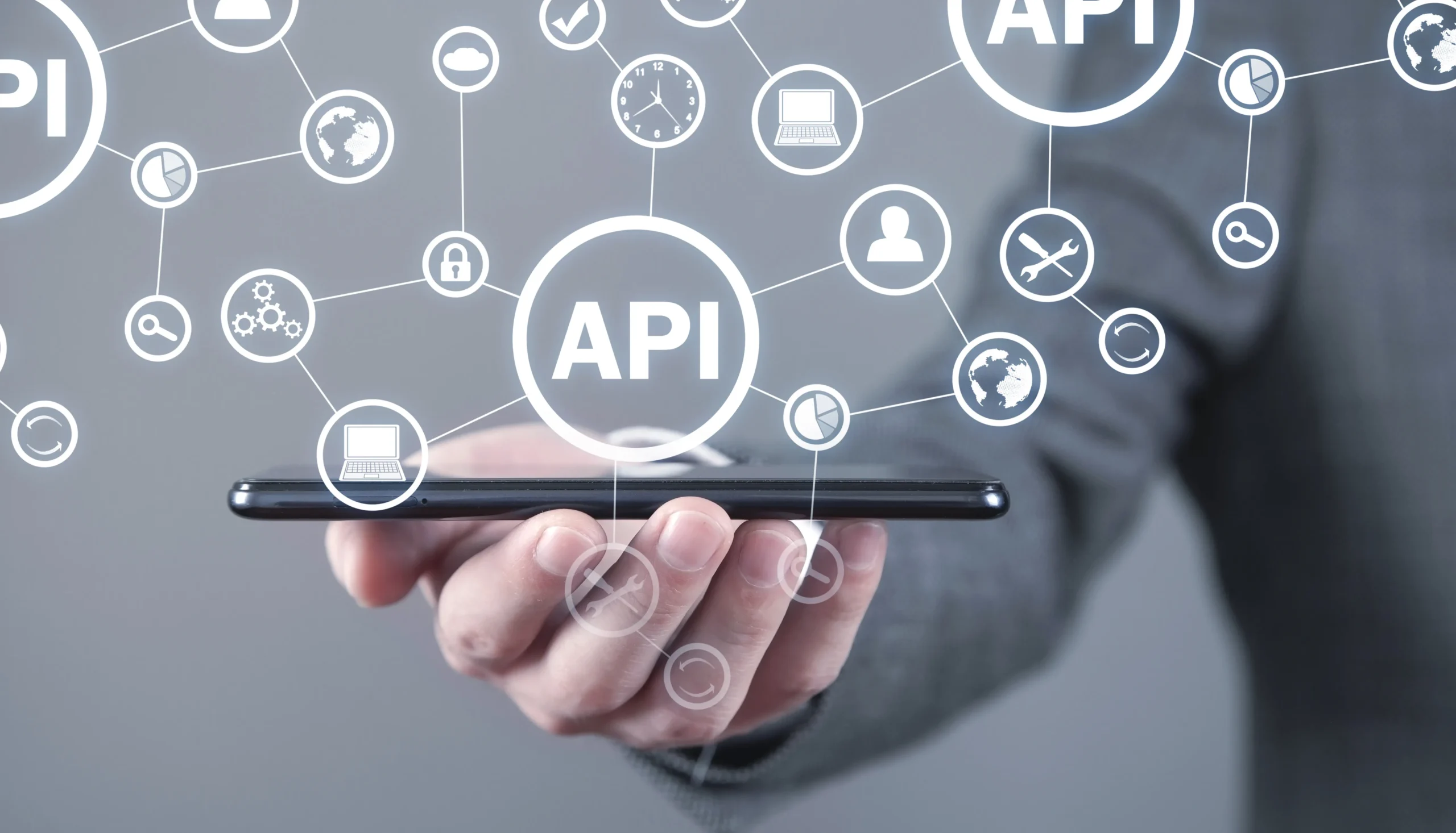 Hand holding smartphone with API icons representing best eSignature API providers and electronic signature API software for seamless integration.