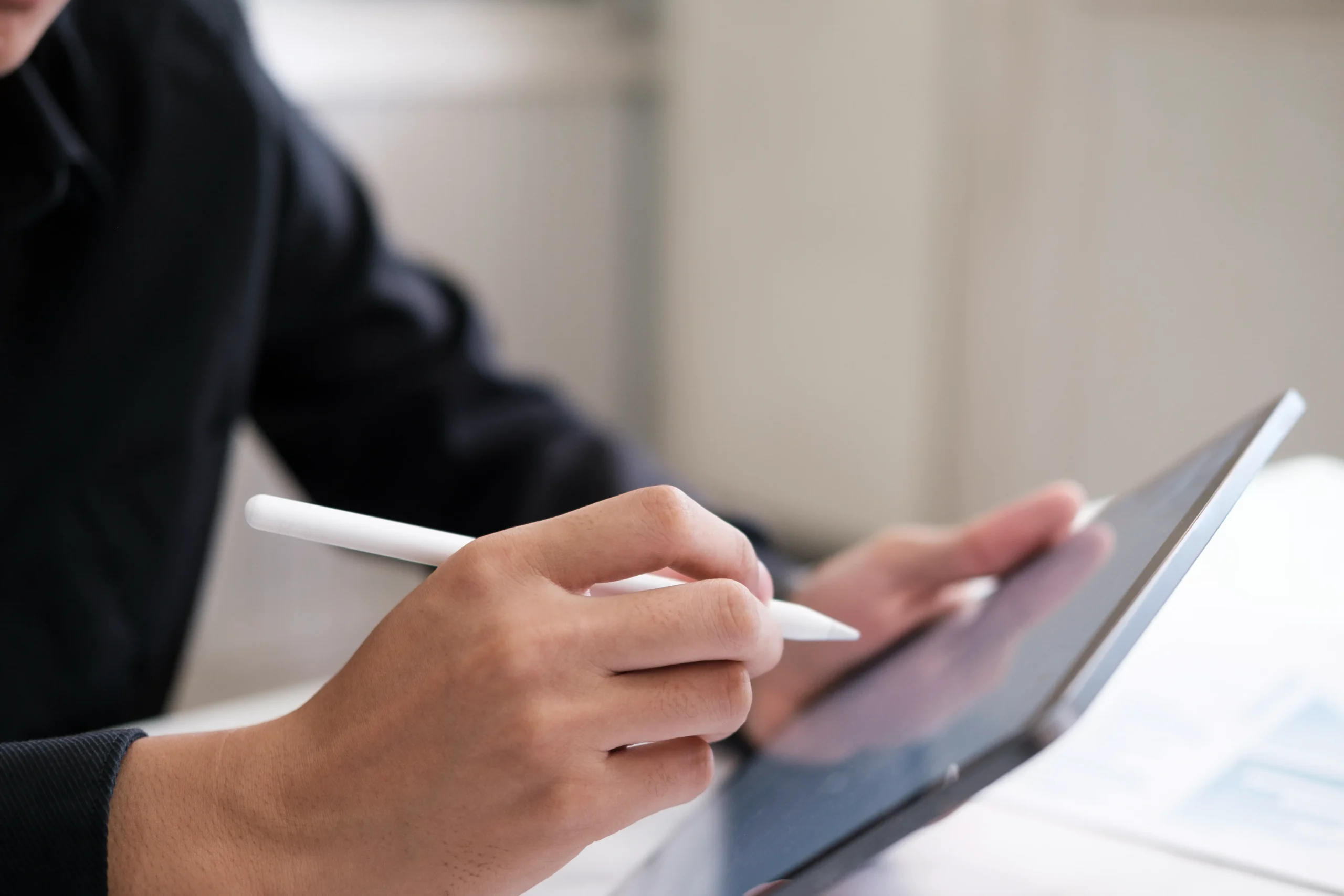 Hands signing paper contracts on a wooden desk, emphasizing the need for a modern, secure HIPAA compliant eSignature workflow.
