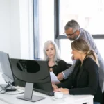 A team of office professionals collaborating and reviewing contracts while using the best DocuSign alternative - SignBulb.