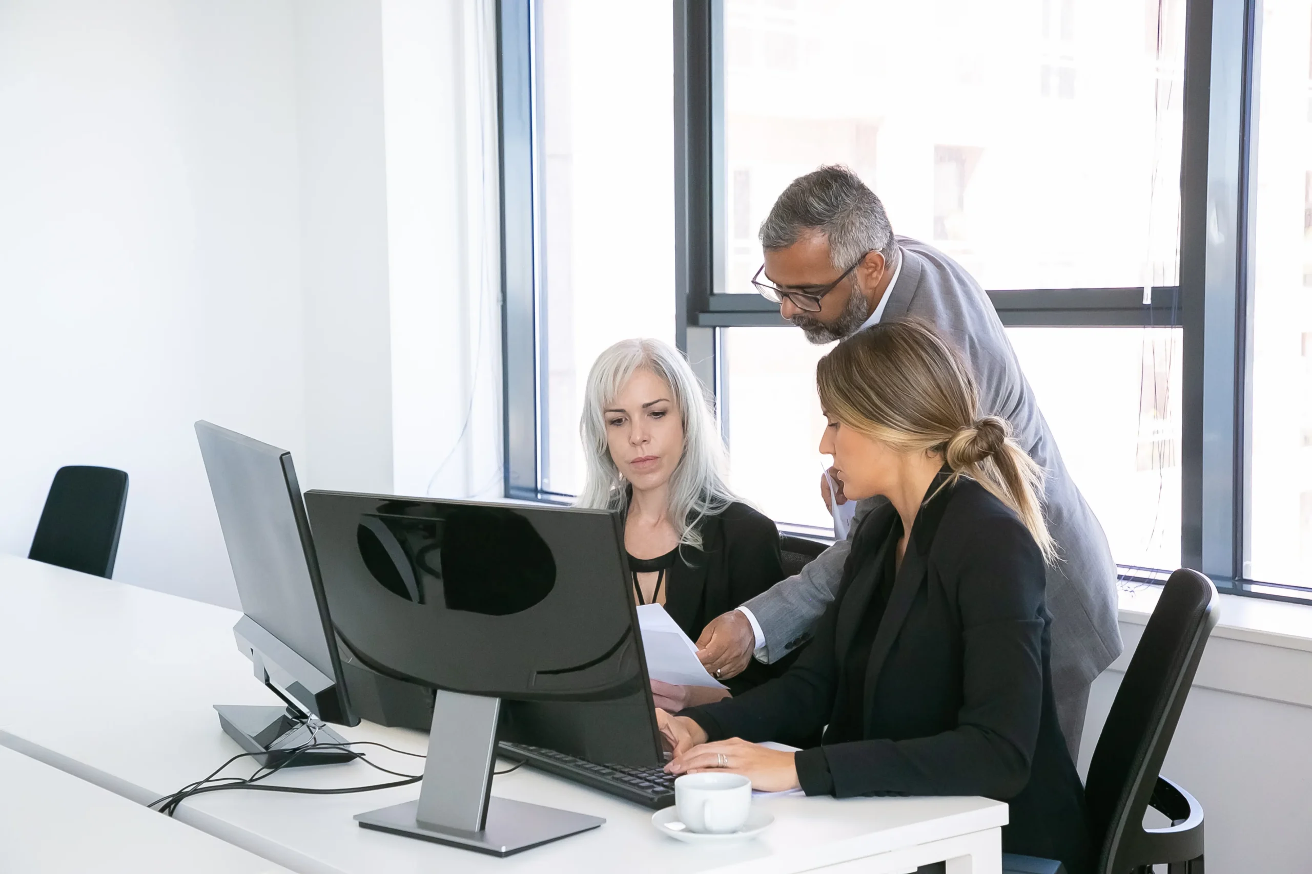 A team of office professionals collaborating and reviewing contracts while using the best DocuSign alternative - SignBulb.
