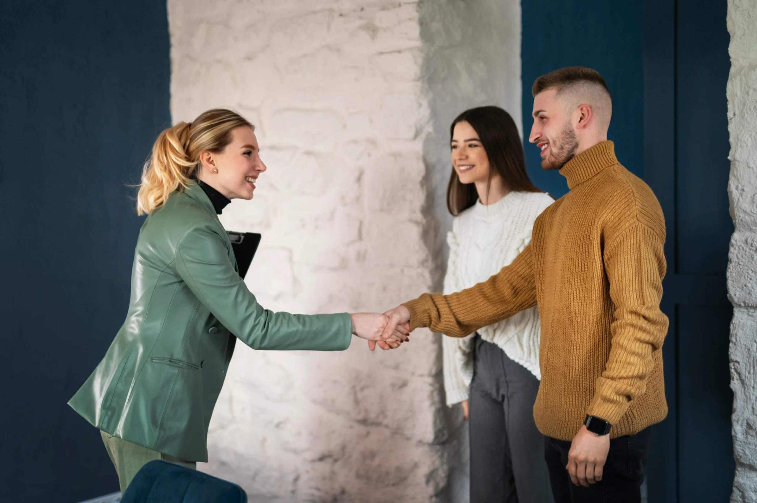 A smiling event manager shaking hands with clients after completing a contract, highlighting how an eSignature for event management streamlines the booking process.