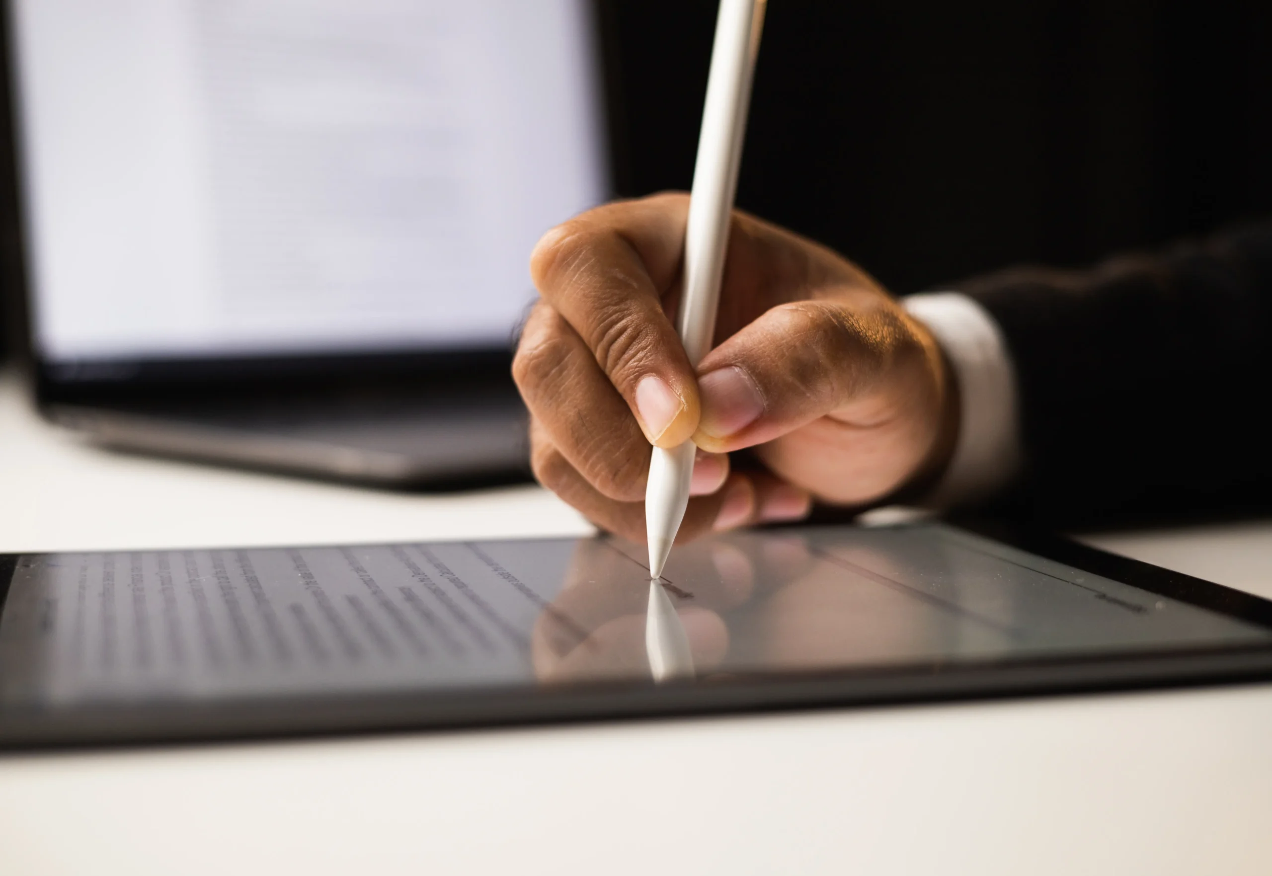 Close-up of a hand signing a digital agreement on a tablet screen using electronic signatures for businesses.