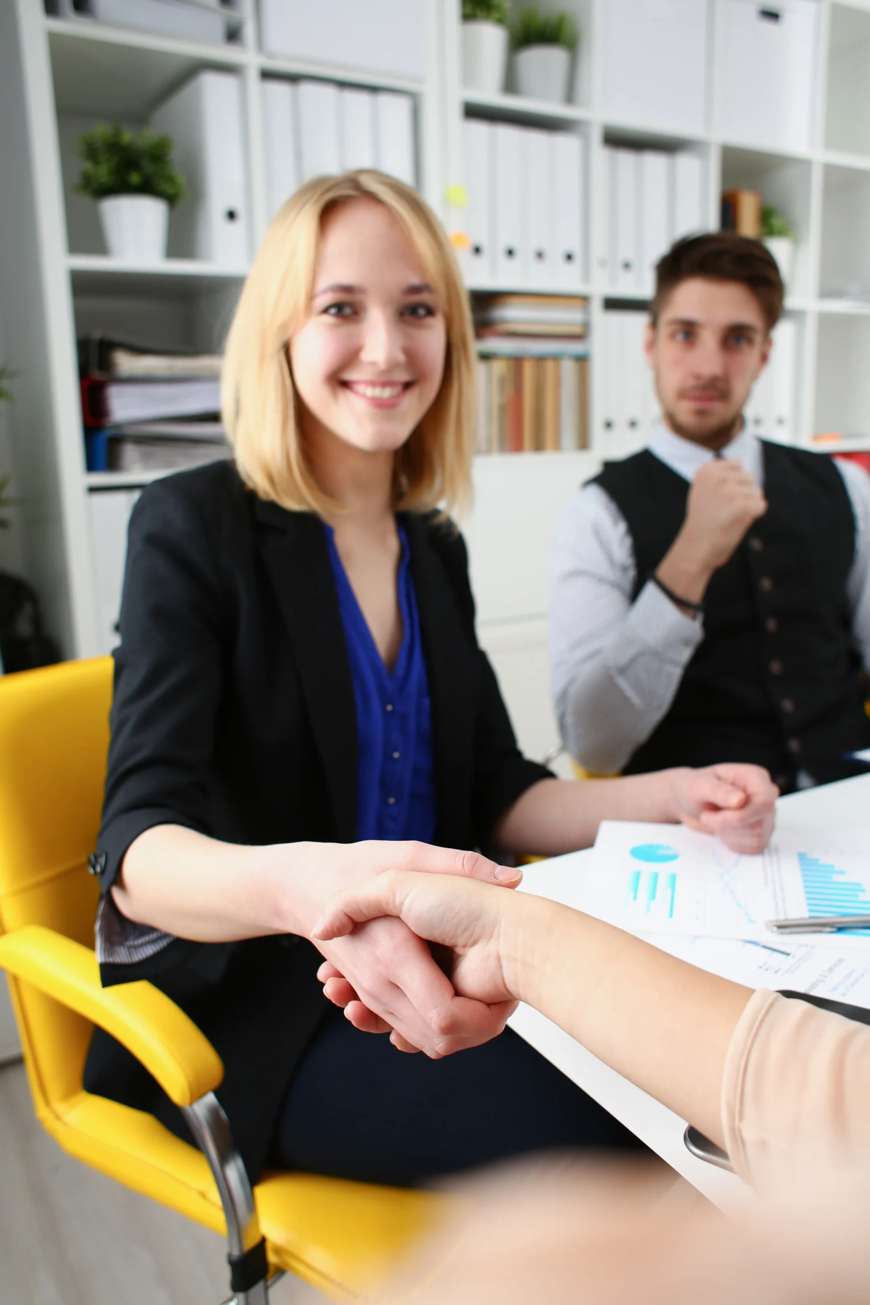 HR professional shaking hands with a new employee after completing eSignature HR onboarding.