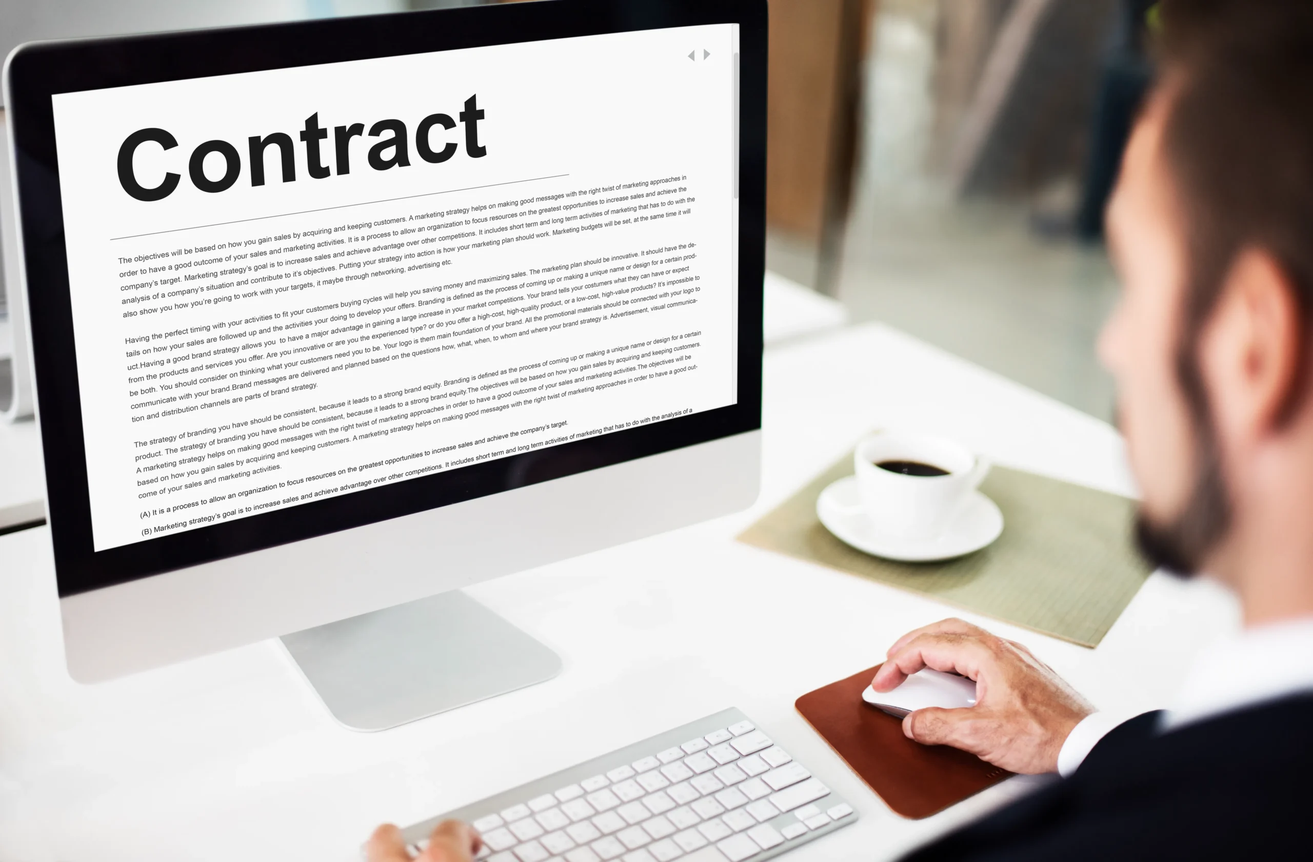 Procurement specialist reviewing a digital contract on a desktop computer screen for procurement contract signing.