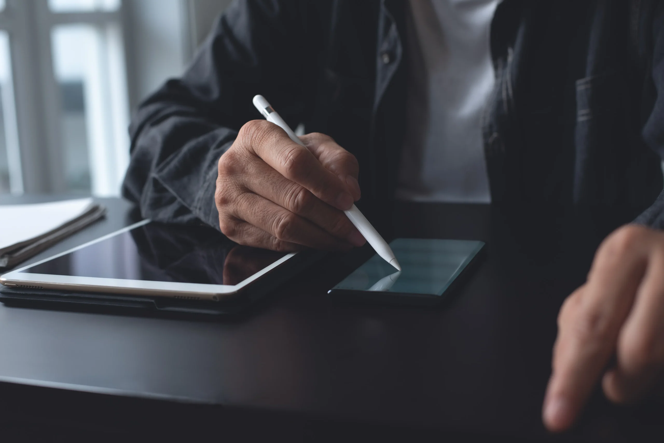 Person using a digital stylus to sign documents on a smartphone screen via Esignature for Procurement.