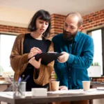 Startup partners reviewing paper documents before uploading them into contract signing software for startups.