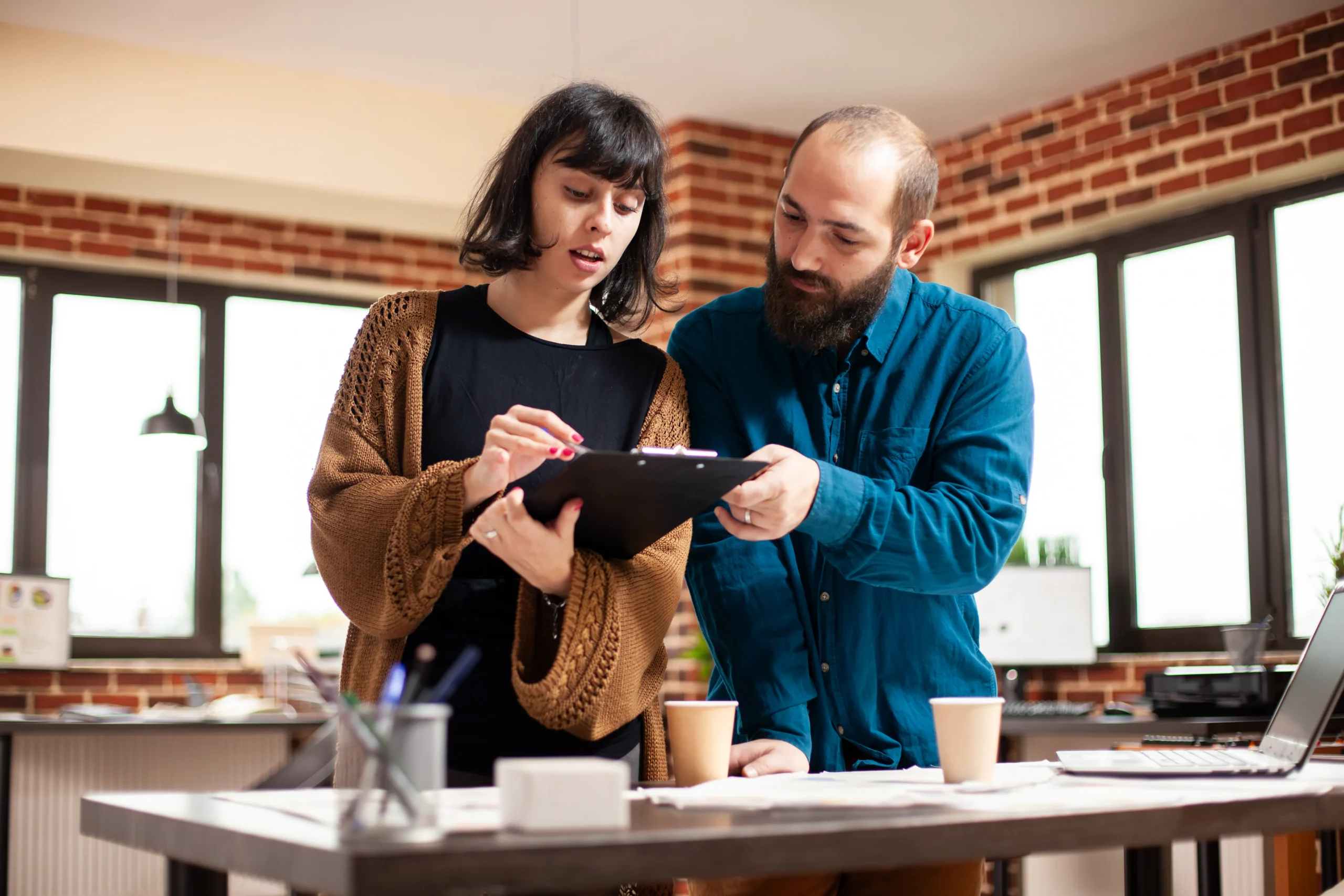 Startup partners reviewing paper documents before uploading them into contract signing software for startups.