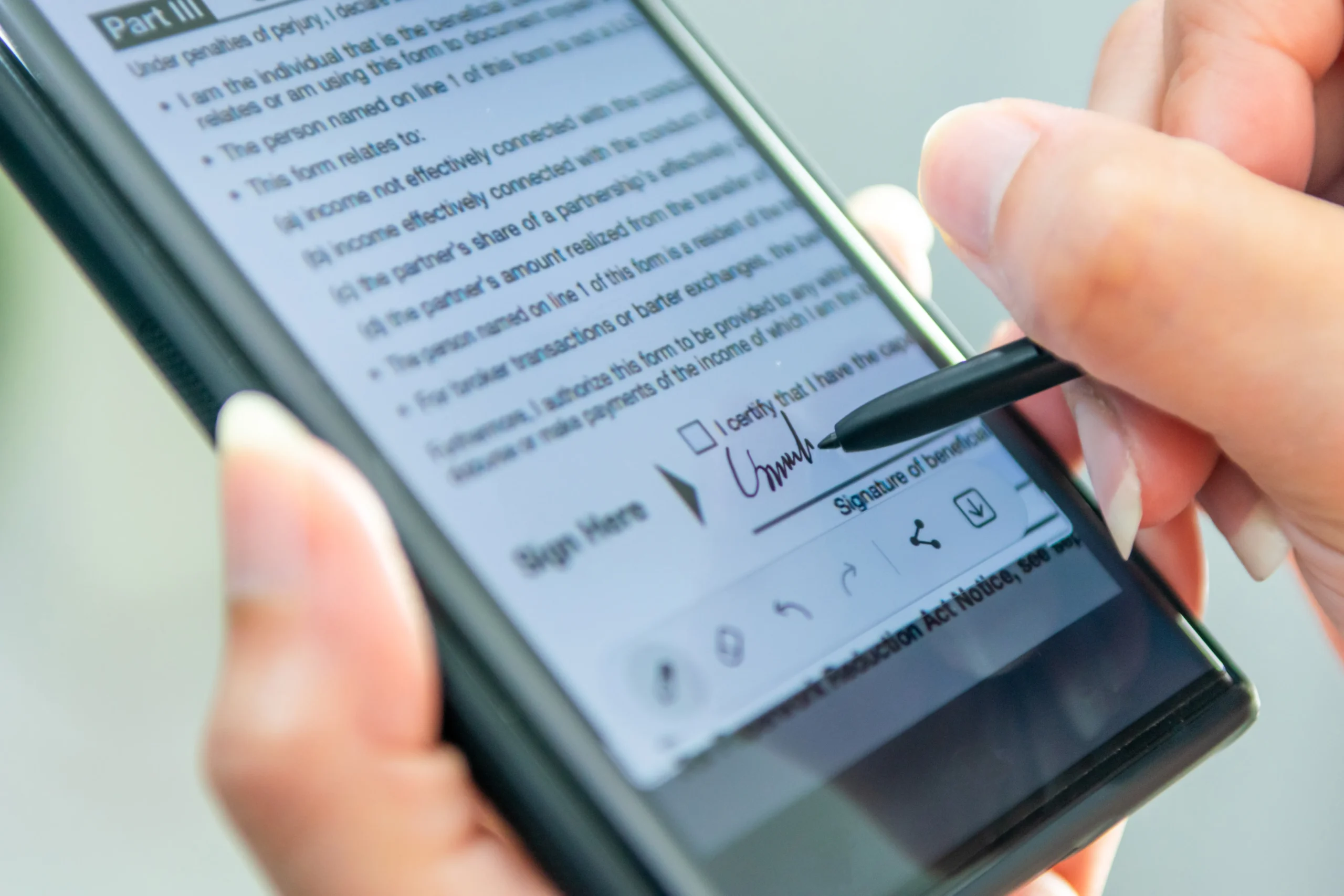 Illustration of two colleagues reviewing a digital contract on a giant smartphone screen to select eSignature software for business.