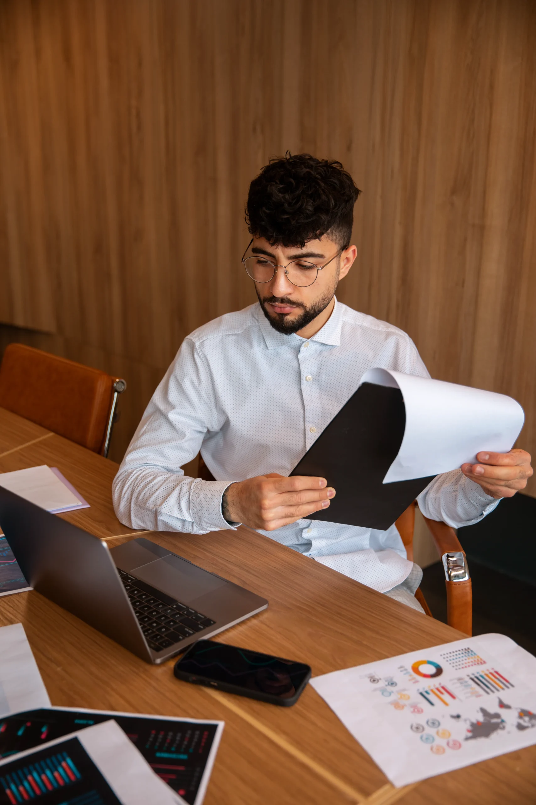 Business professional reviewing printed paperwork before transitioning to a mobile esignature system.