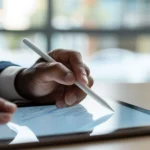 User writing a digital signature on a tablet device integrated with an esignature API.