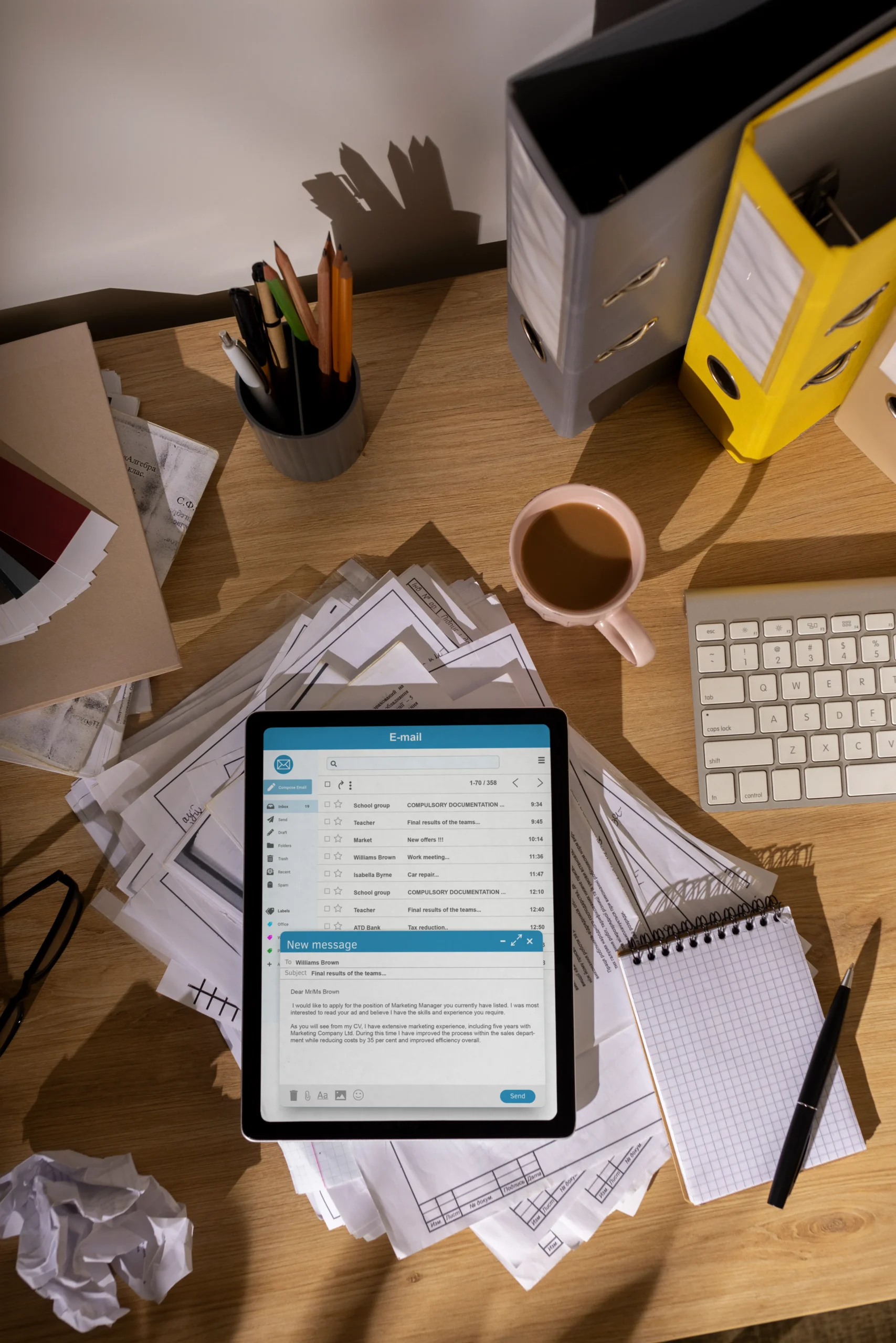 Desktop tablet displaying email notifications and file folders used in exclusion compliance screening.